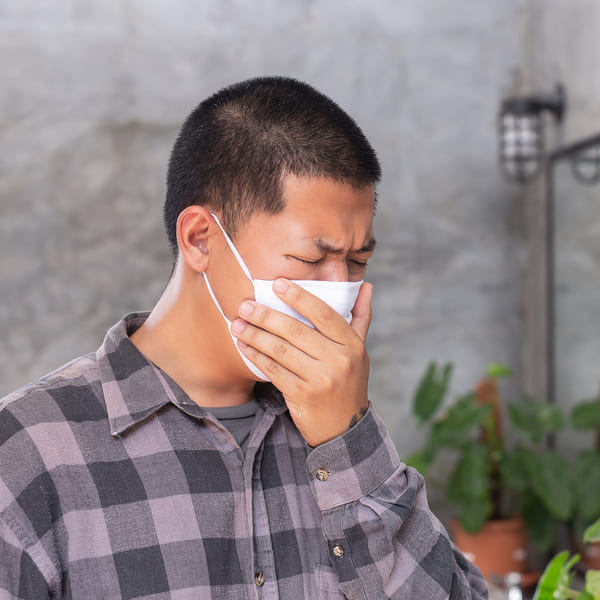 Young boy is waring protect mask and close his mouth by hand for